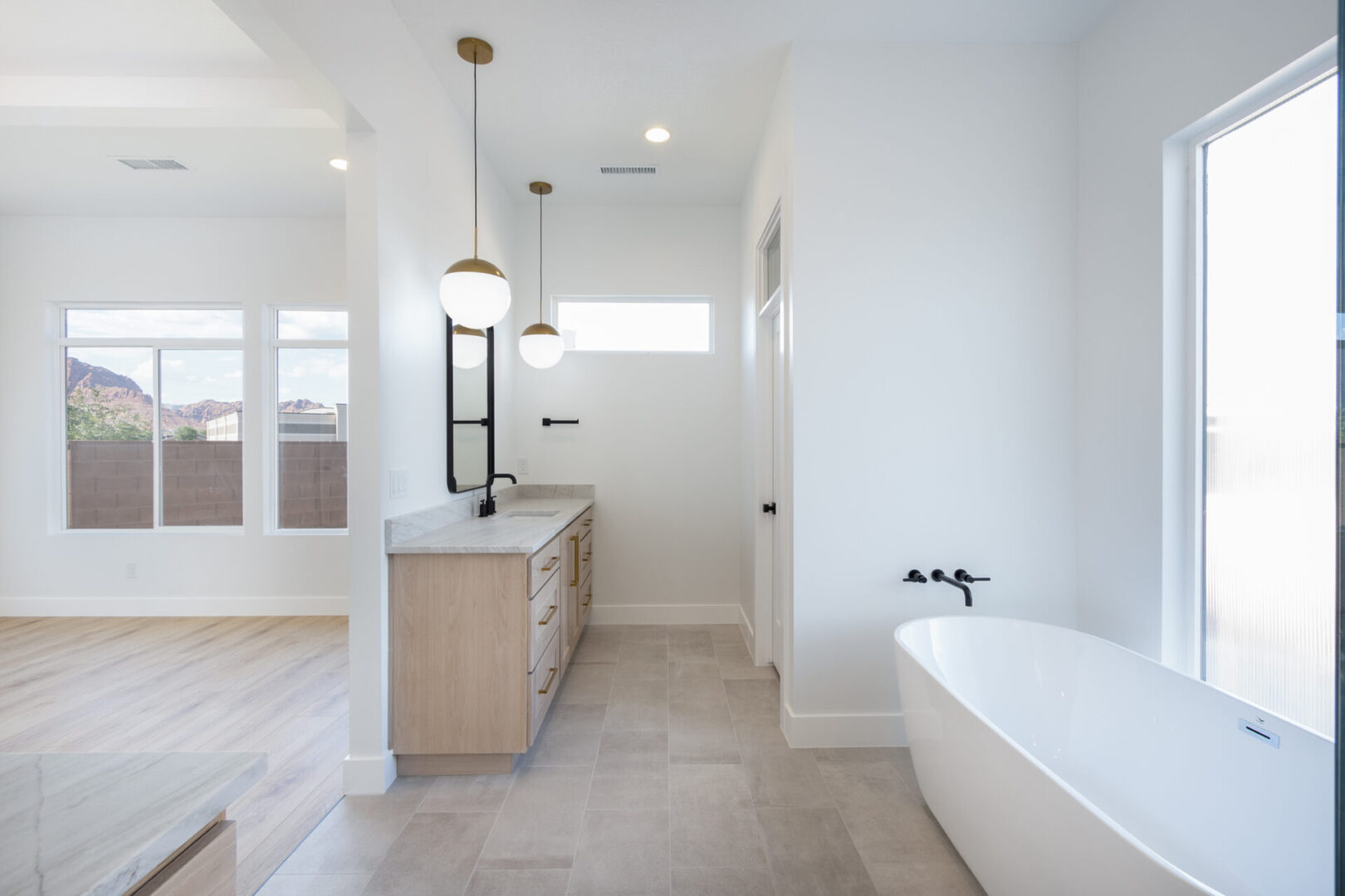 A white bathtub near a light brown cabinet and bathroom sink