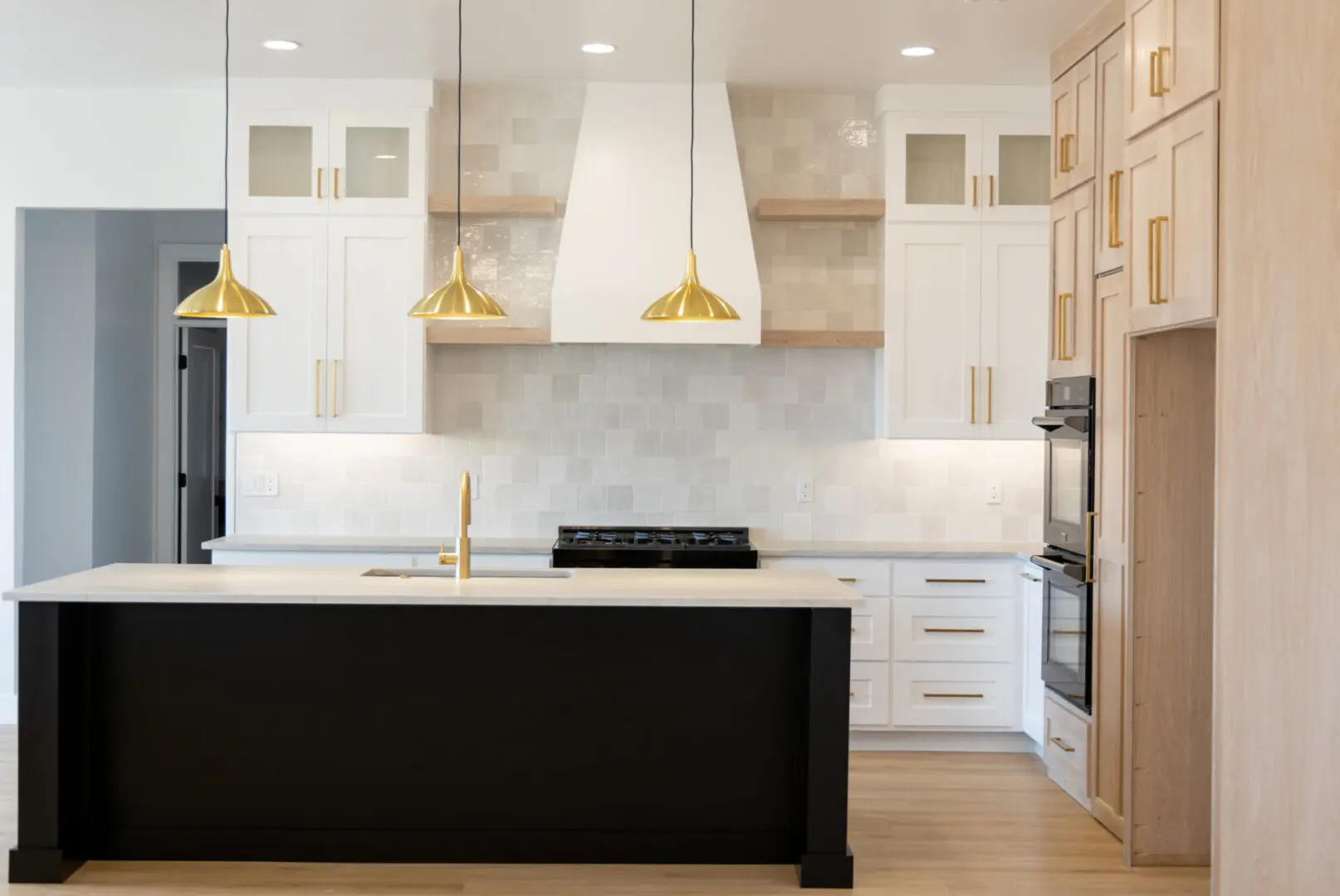 The kitchen area with three gold lights